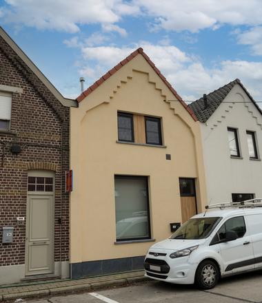 Gevelrenovatie met crepi in Nederename Rijhuis in Nederename met lichtgele crepi en blauwe steen..